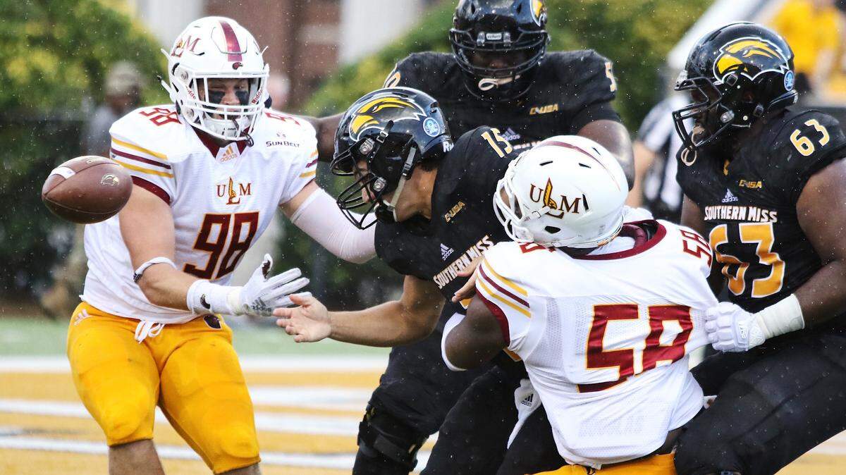 Southern Miss quarterback Jack Abraham (15) loses a fumble into his own end zone while being hit by ULM defensive end Donald Louis Jr. Saturday in Hattiesburg. ULM’s Sam Miller (98) recovered the fumble for a touchdown in the first quarter.