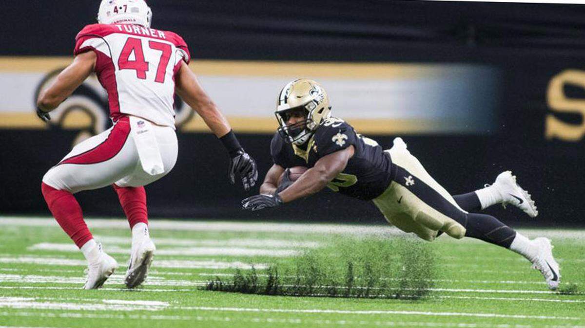 Arizona Cardinals safety Zeke Turner, 47, runs after New Orleans Saints running back Boston Scott, 30, as he hugs the ball while going down in a preseason game in New Orleans on Aug. 17, 2018.