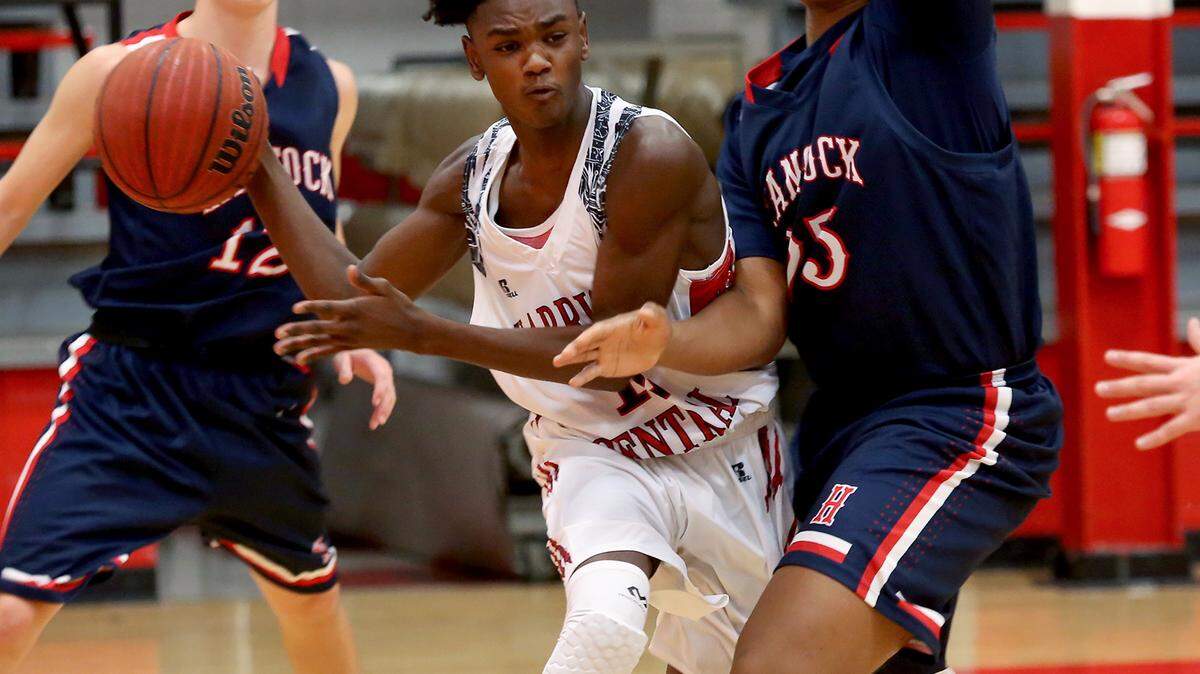 AMANDA McCOY/SUN HERALD 
 Harrison Central's Anthony Barnett passes the ball while being pressured by Hancock High's Aaron Feazelle on Tuesday, January 5, 2016. Harrison Central defeated Hancock, 67-55.