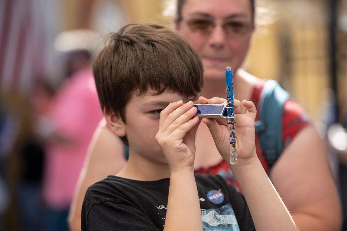 Jackson Perez, 10, of Vancleave, looks through a kaleidoscope for sale at KaleidoArt during the Peter Anderson Festival in Ocean Springs on Sunday, Nov. 6, 2022.
