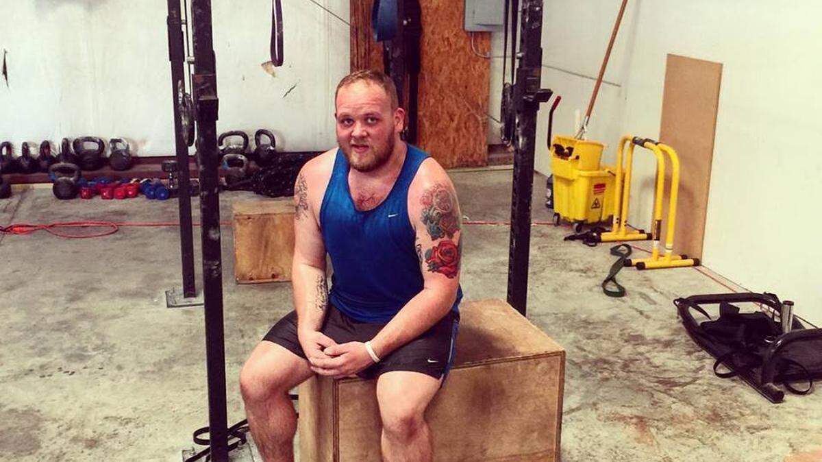 Justin Mitchell rests after finishing a workout at CrossFit Portside in Gulfport on Wednesday, July 29, 2015.