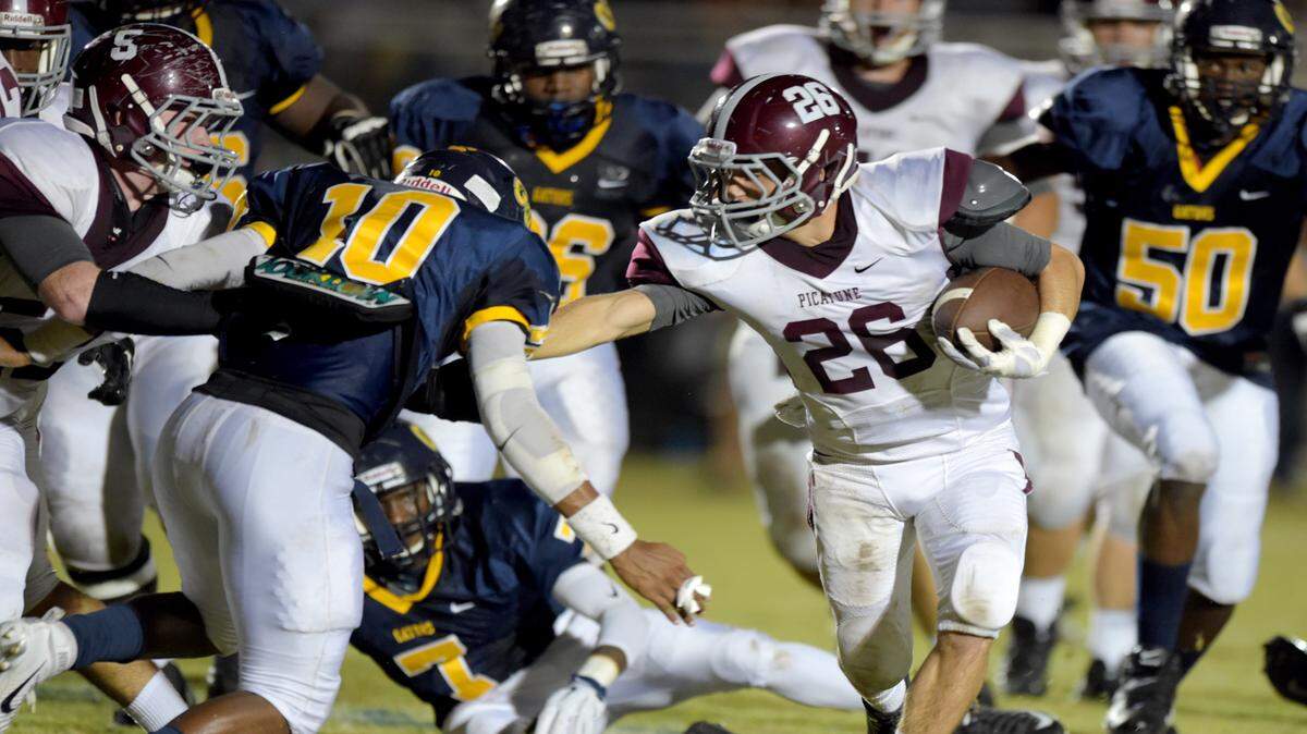 GLENN ANDREWS/SPECIAL TO THE SUN HERALDPicayune running back Trey Wimbrow (26) tries to stiff arm his way past Gautier strong safety James Lott (10) during a game earlier this season.