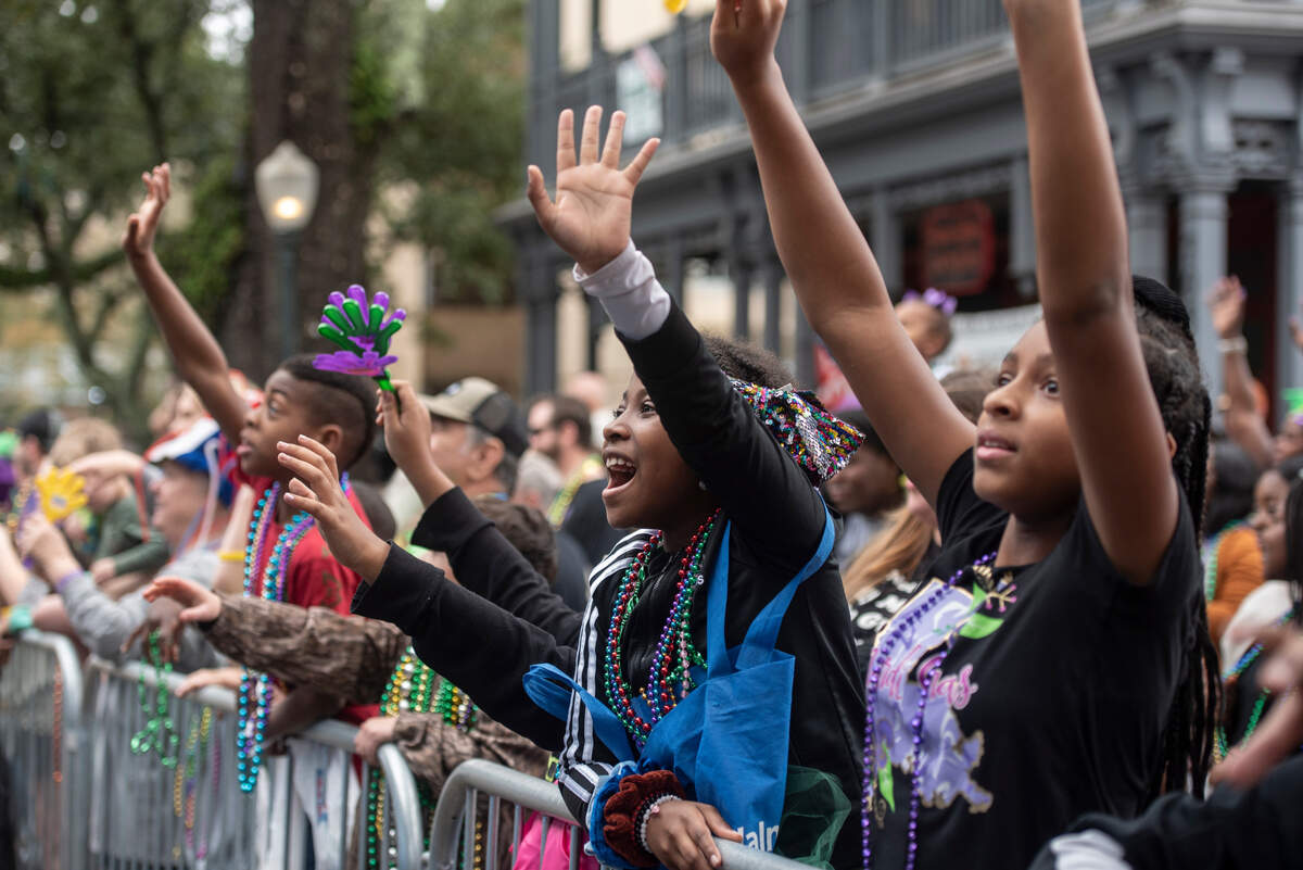 Parade attendees cheer for beads during The Ocean Springs Elks Carnival Parade in downtown Ocean Springs on Saturday, Jan. 27, 2024.