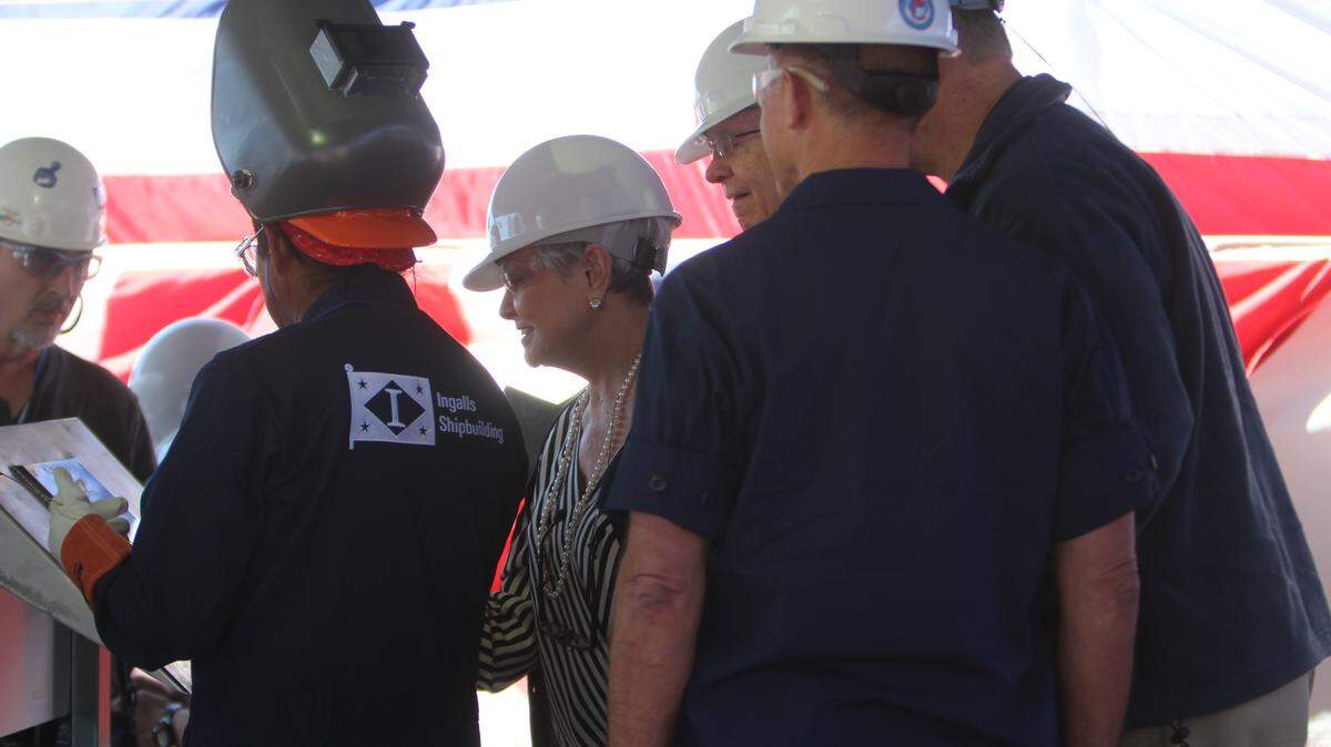 JEFF CLARK/SUN HERALD 
 Kay Cochran signs her initials on the keel of the NSC Kimball on Friday.