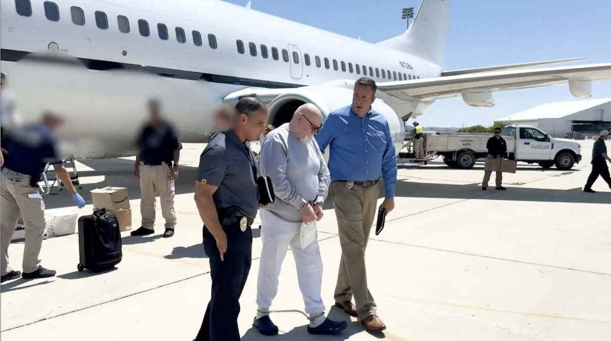 Warren Luther Alexander, 73, is escorted by authorities during his extradition from North Carolina to Southern California, where he is charged in the 1977 murders of three women.