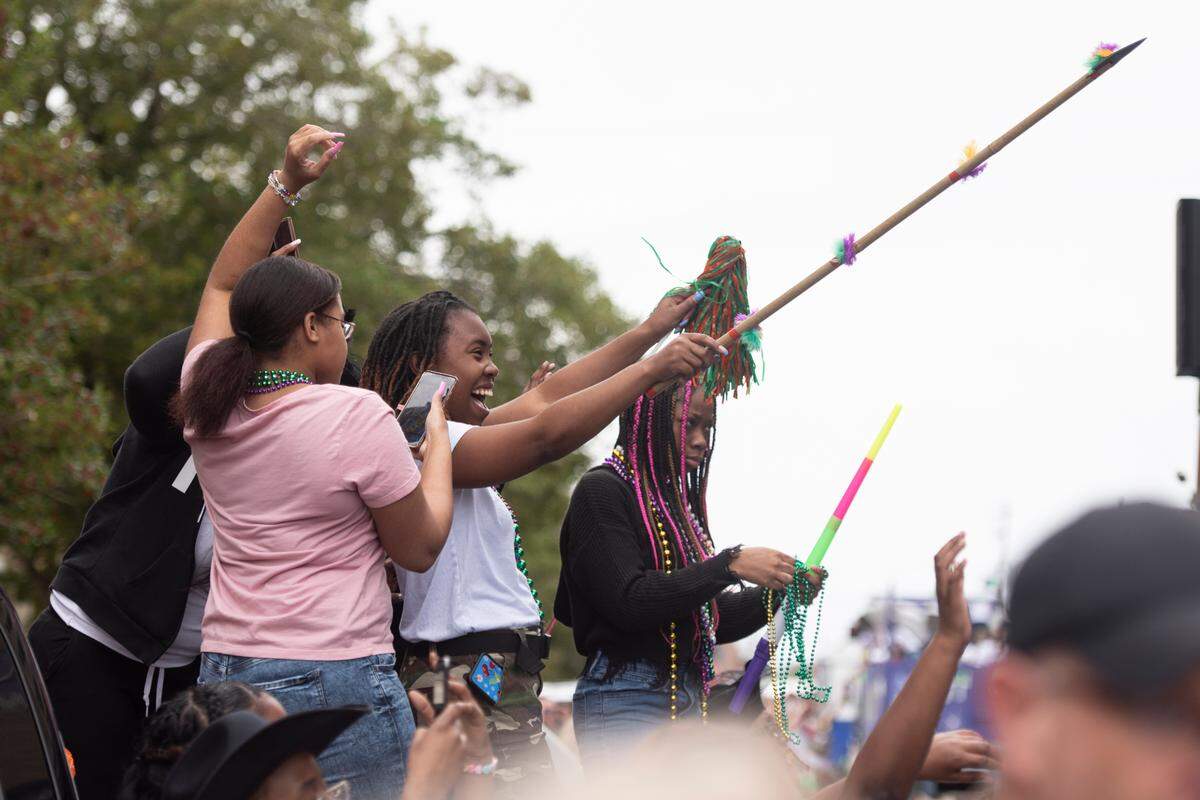 Paradegoers catch beads during the Krewe of Gemini parade in downtown Gulfport on Saturday, Feb. 10, 2024.