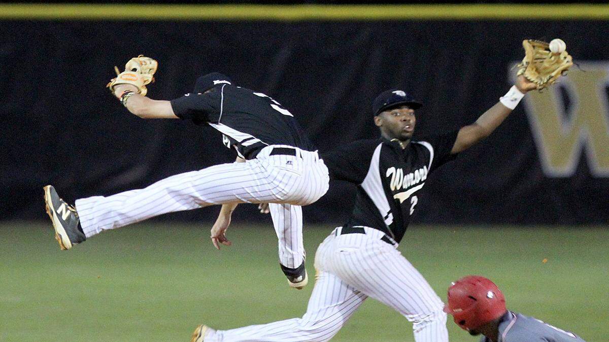TIM ISBELL/SUN HERALD 
 D'Iberville shortstop Luther Woullard catches a high throw that sailed over the head of Nathan Yennie, Friday, Apr. 22, 2016.