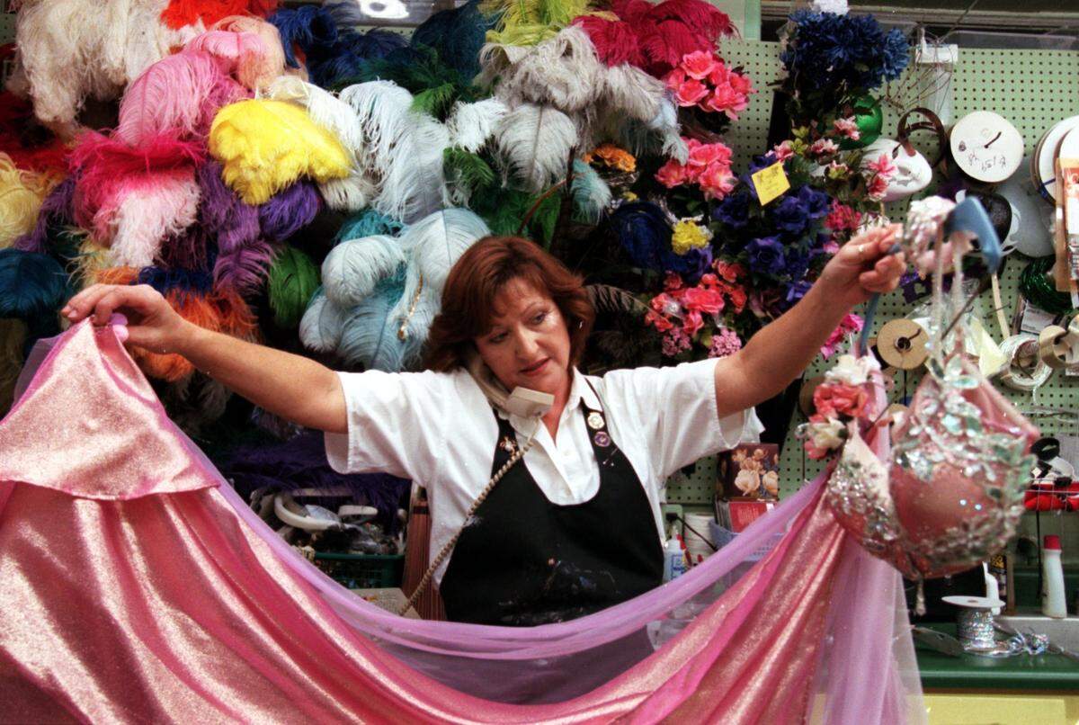 Costume designer, Margie McGraw holds up a fairy’s Mardi Gras costume while telling the customer on the phone that it’s ready for pick-up at the former Josette’s in Biloxi. She started working on Mardi Gras costumes in June and is still getting last minute orders.