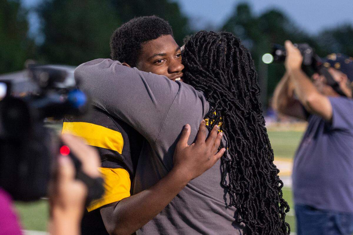 Tyler Hunter, the student manager for D’Iberville’s JV football team, hugs his mom after playing in a game against St. Martin at Warrior Stadium in D’Iberville on Monday, Oct. 9, 2023. Both teams made accommodations so that Hunter, who has an intellectual disability, could get playing time.