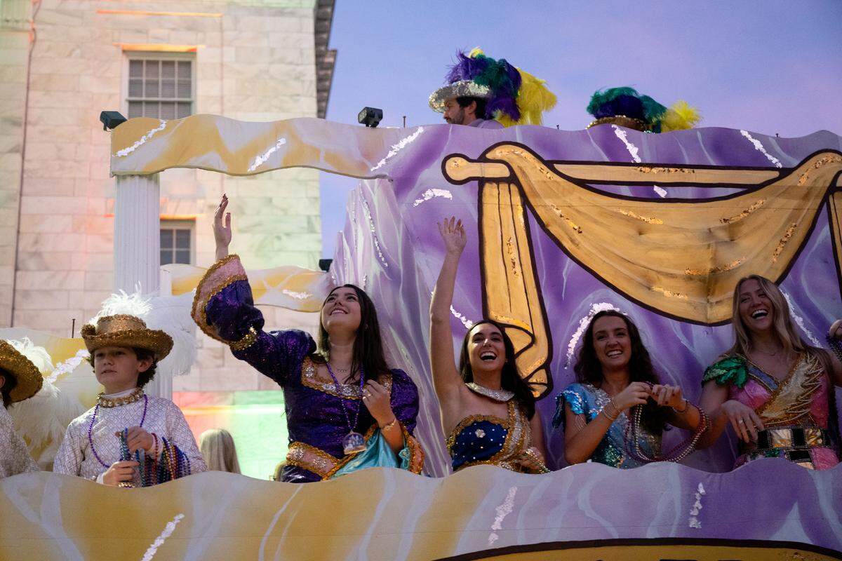 Parade attendees laugh as they toss beads and flowers from their floats during a 12th Night Celebration in Biloxi on Monday, Jan. 5, 2026.