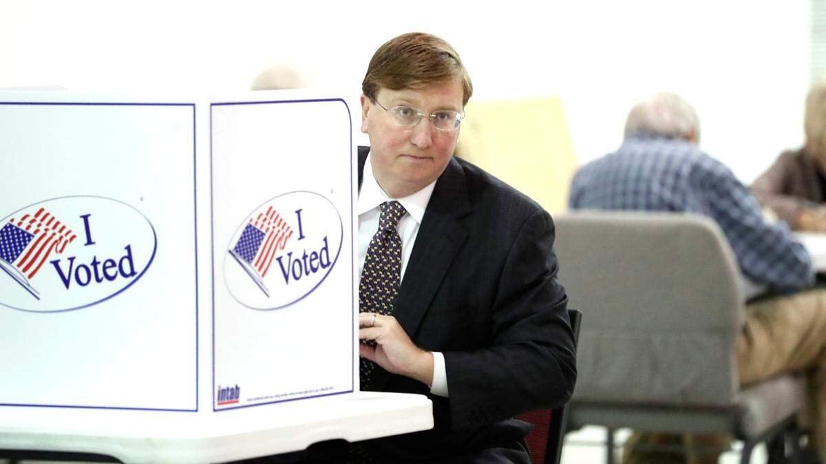 Republican nominee for governor and current Lt. Gov. Tate Reeves, peers around his voting kiosk while voting in the general election, Tuesday Nov. 5, 2019 in Flowood, Miss.