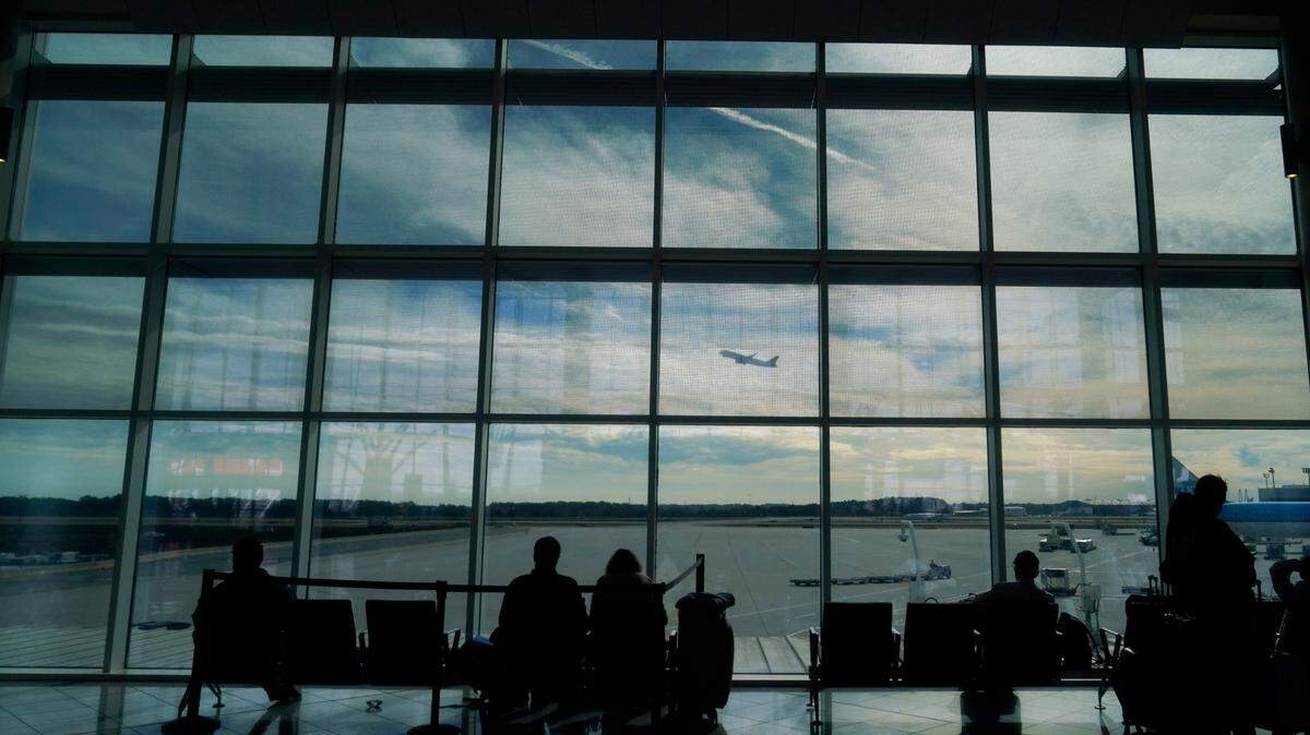 FILE - Travelers watch as a plane takes off from Hartsfield-Jackson Atlanta International Airport in Atlanta, Tuesday, Nov. 22, 2022. On Friday, Jan. 27, 2023, The Associated Press reported on stories circulating online incorrectly claiming the FAA loosened the requirements that airline pilots must meet for cardiac health because of COVID-19 vaccine side effects. (AP Photo/Brynn Anderson, File)