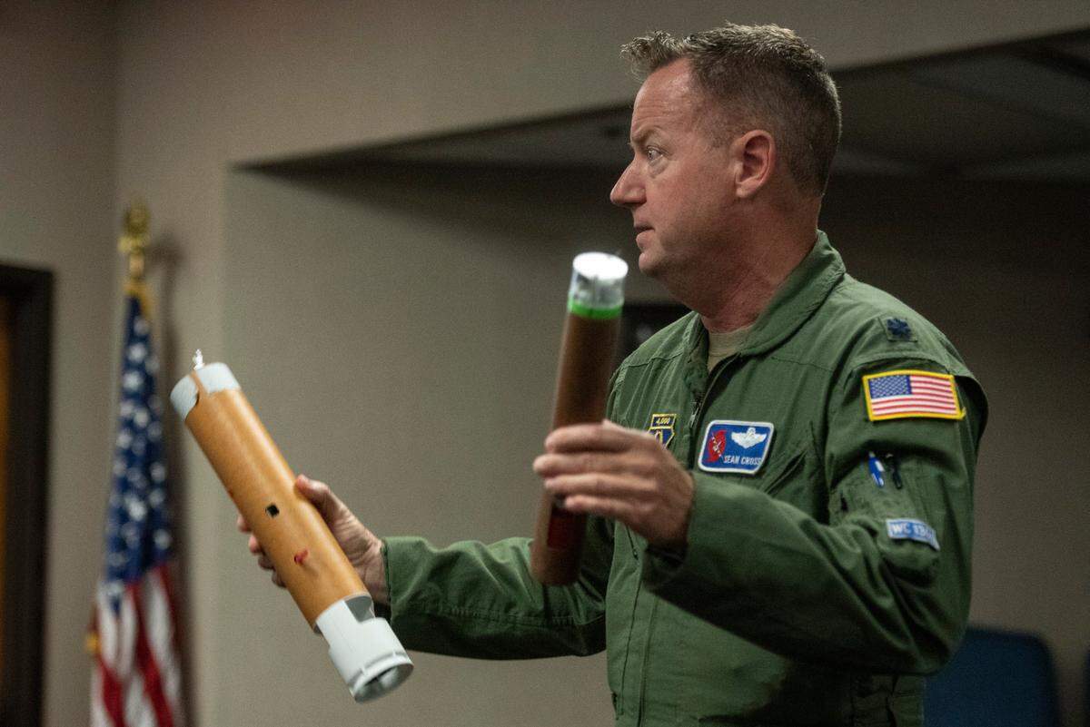 Lt. Col. Sean Cross, chief of safety for the 403rd Wing, demonstrates what a dropsonde is during a media day at Keesler Air Force Base on Tuesday, May 6, 2025. A dropsonde is a device dropped out of planes by the Hurricane Hunters to collect weather data.