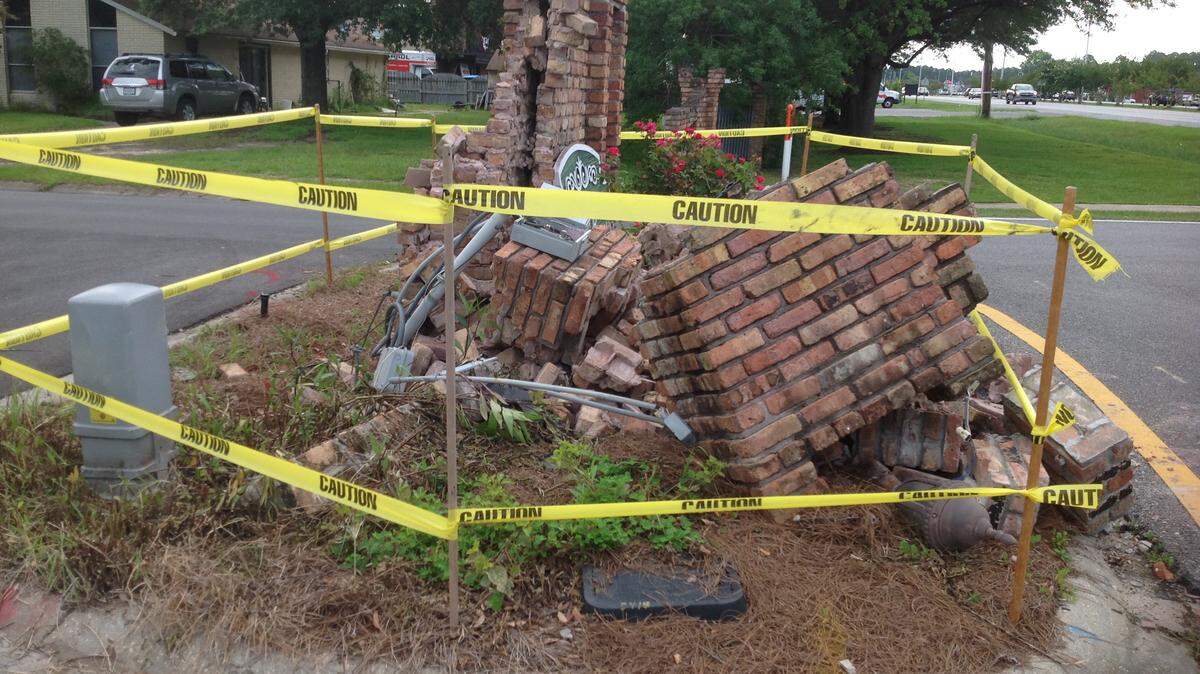 KAREN NELSON/SUN HERALDThe big, brick entry to Fort Bayou Estates along U.S. 90 in Ocean Springs was smashed over the weekend. On Thursday, caution tape went up around it. The big subdivisoin near downtown has been around for decades.