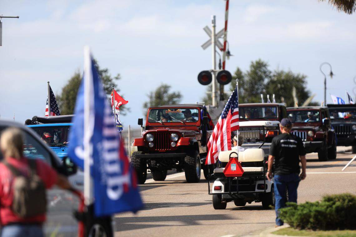 Women in one Jeep converse with a woman driving a golf cart during a Jeep parade supporting President Donald Trump on Saturday, Sept. 12, 2020, in Bay St. Louis, Mississippi.
