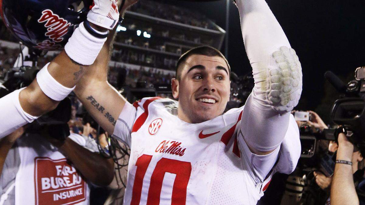 Mississippi quarterback Chad Kelly (10) hoists the Egg Bowl trophy as he celebrates his team's 38-27 win over Mississippi State in an NCAA college football game in Starkville, Miss., Saturday, Nov. 28, 2015. (AP Photo/Rogelio V. Solis)