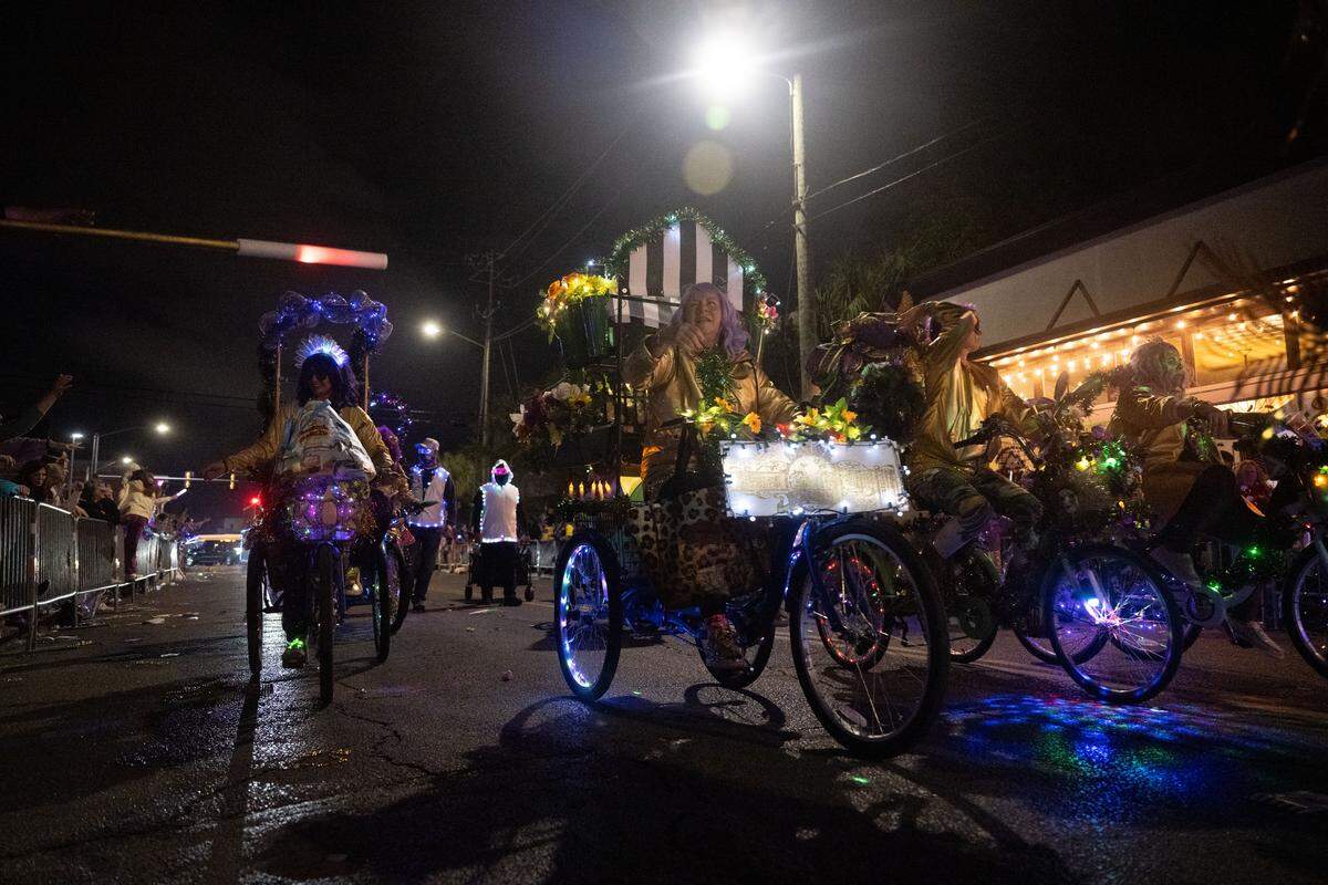 Parade participants on bikes pass out items during the Krewe of Neptune parade in Biloxi on Saturday, Feb. 14, 2026.