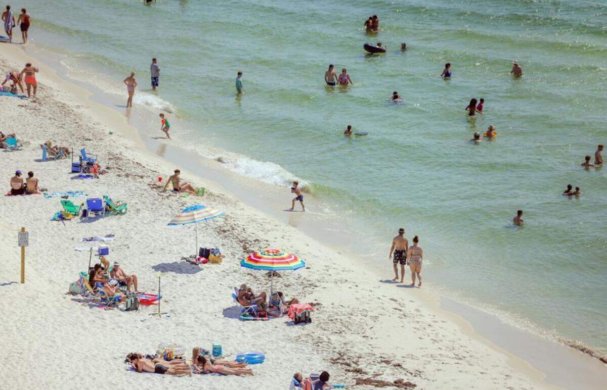 Beachgoers are seen on the sand and in the water at Perdido Pass in Orange Beach, Ala., on Friday, June 7, 2024.