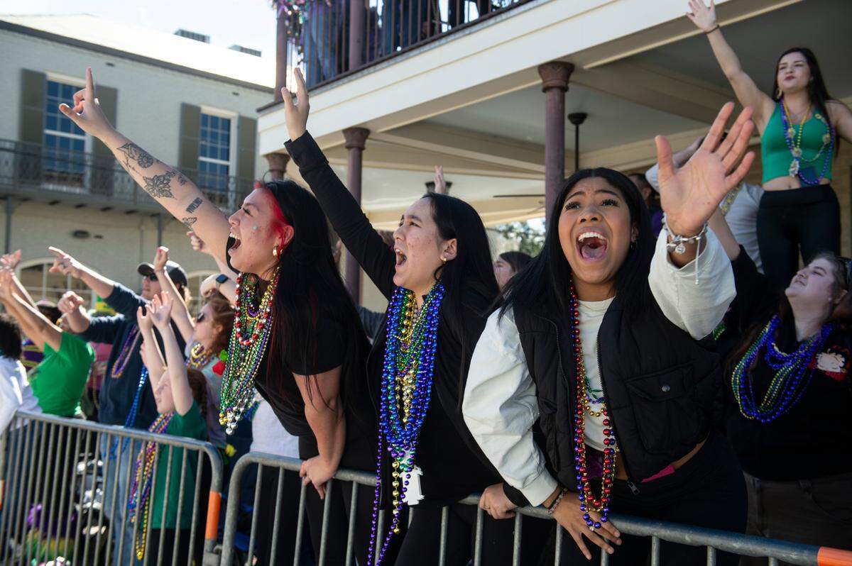 Paradegoers catch beads during the Gulf Coast Carnival Association’s Mardi Gras parade in Biloxi on Tuesday, Feb. 13, 2024.
