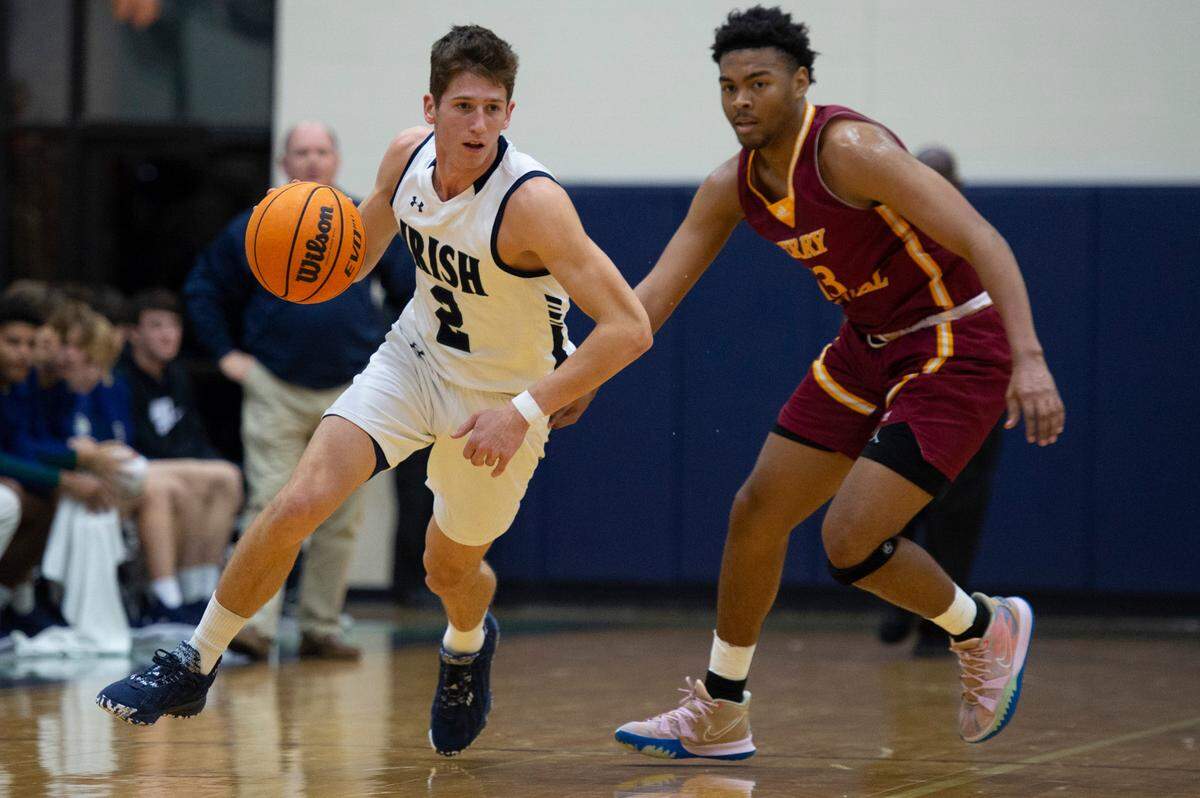 St. Patrick guard Nick Krass, left, dribbles the ball past Perry Central’s Trace Hinton during a game against Perry Central at St. Patrick Catholic High School on Thursday, Jan. 13, 2022.