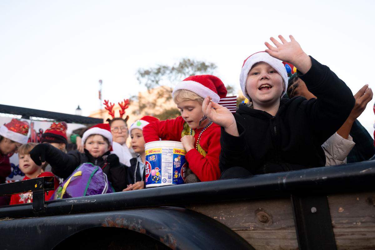 Children pass out candy from parade floats during the Champions Christmas Parade in Gulfport on Monday, Dec. 8, 2025.