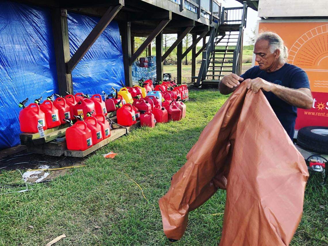 Donald Dardar covers full gasoline canisters at the Pointe-au-Chien tribal center in September 2021. Volunteers from New Orleans and other cities in Louisiana deliver supplies to the tribal almost daily.
