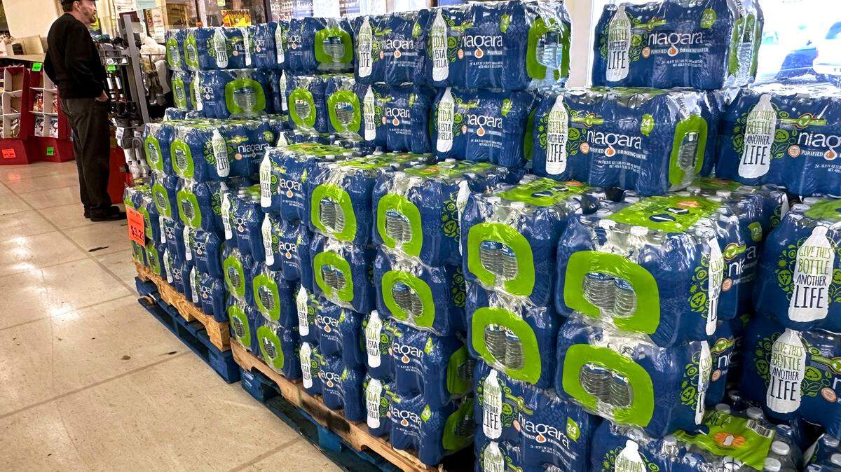 A shopper at a downtown Jackson grocery store, stands by several pallets of packaged drinking water in preparation of several days of extreme cold throughout the state.