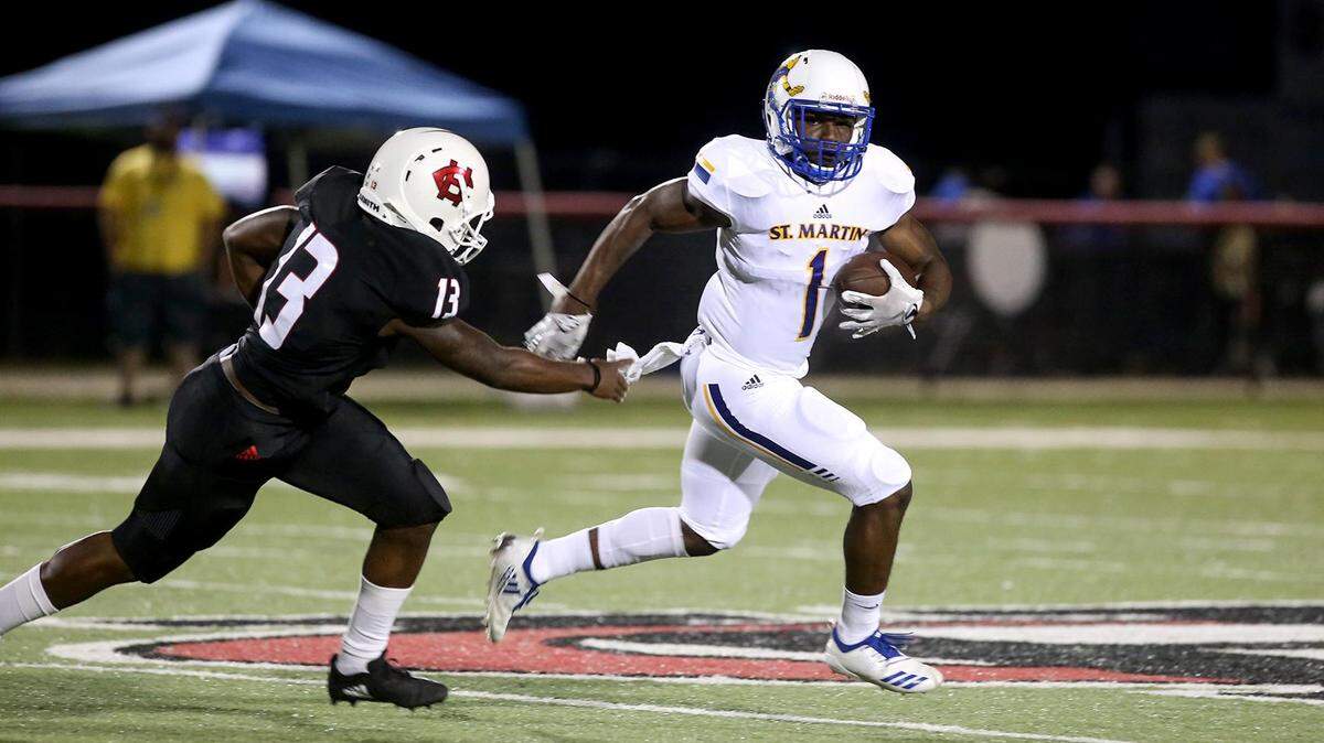St. Martin’s Hamm McGee runs the ball with Harrison Central’s Jerprice Preston in pursuit on Friday, October 5, 2018.