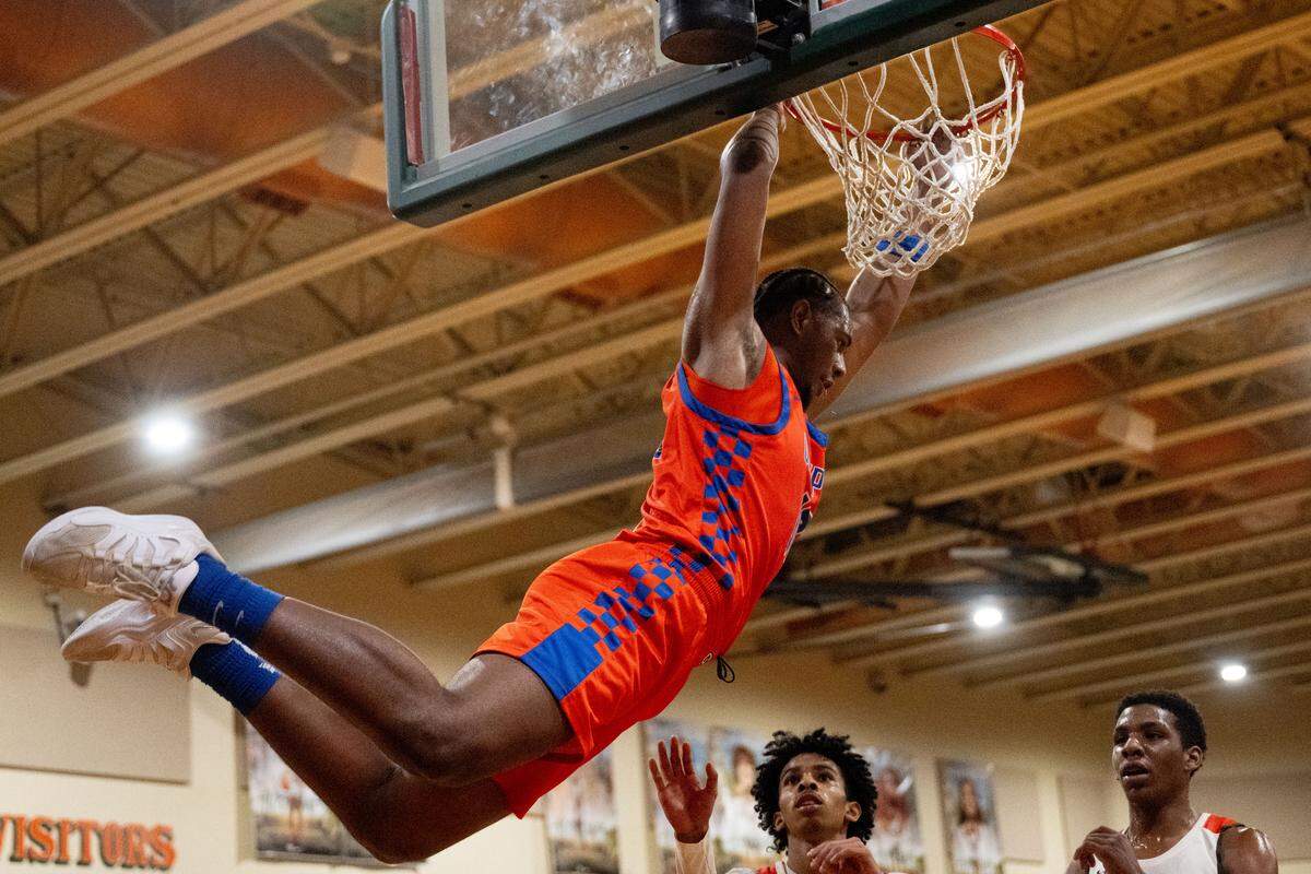 Gulfport's Travor Frost (10) hangs from the rim after dunking the ball during a basketball game at West Harrison High School on Tuesday, Jan. 13, 2026.