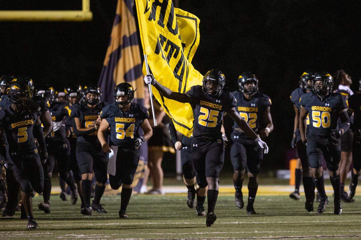 The D’Iberville Warriors run into the stadium before a game against Biloxi at Warriors Stadium in D’Iberville on Friday, Sept. 23, 2022.