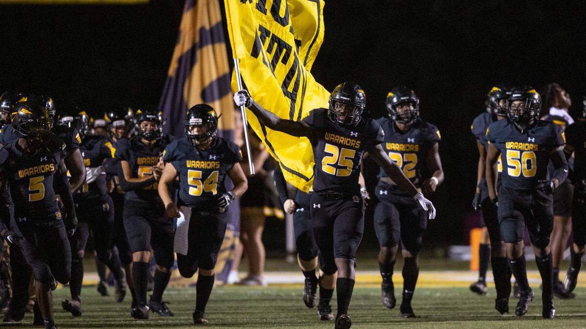 The D’Iberville Warriors run into the stadium before a game against Biloxi at Warriors Stadium in D’Iberville on Friday, Sept. 23, 2022.