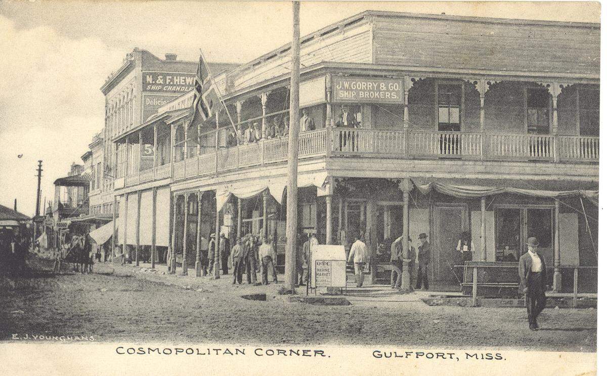 Past: The busy scene pictured on this circa 1915 postcard is described by photographer E. J. Younghans as a “Cosmopolitan Corner” in Gulfport.&nbsp; During the early 1900s, Younghans was well known for his pictures of everyday scenes in Biloxi and Gulfport.&nbsp;The second floor sign identifies the building in the foreground as the J. W. Carry Ship Brokers Co. The sign at the top side of the tall building on the far left identifies it as the N. & F. Hewes Ship Chandler Co., which sold all of the supplies that the ship would need for the long voyage back to its homeland, including groceries.&nbsp; 