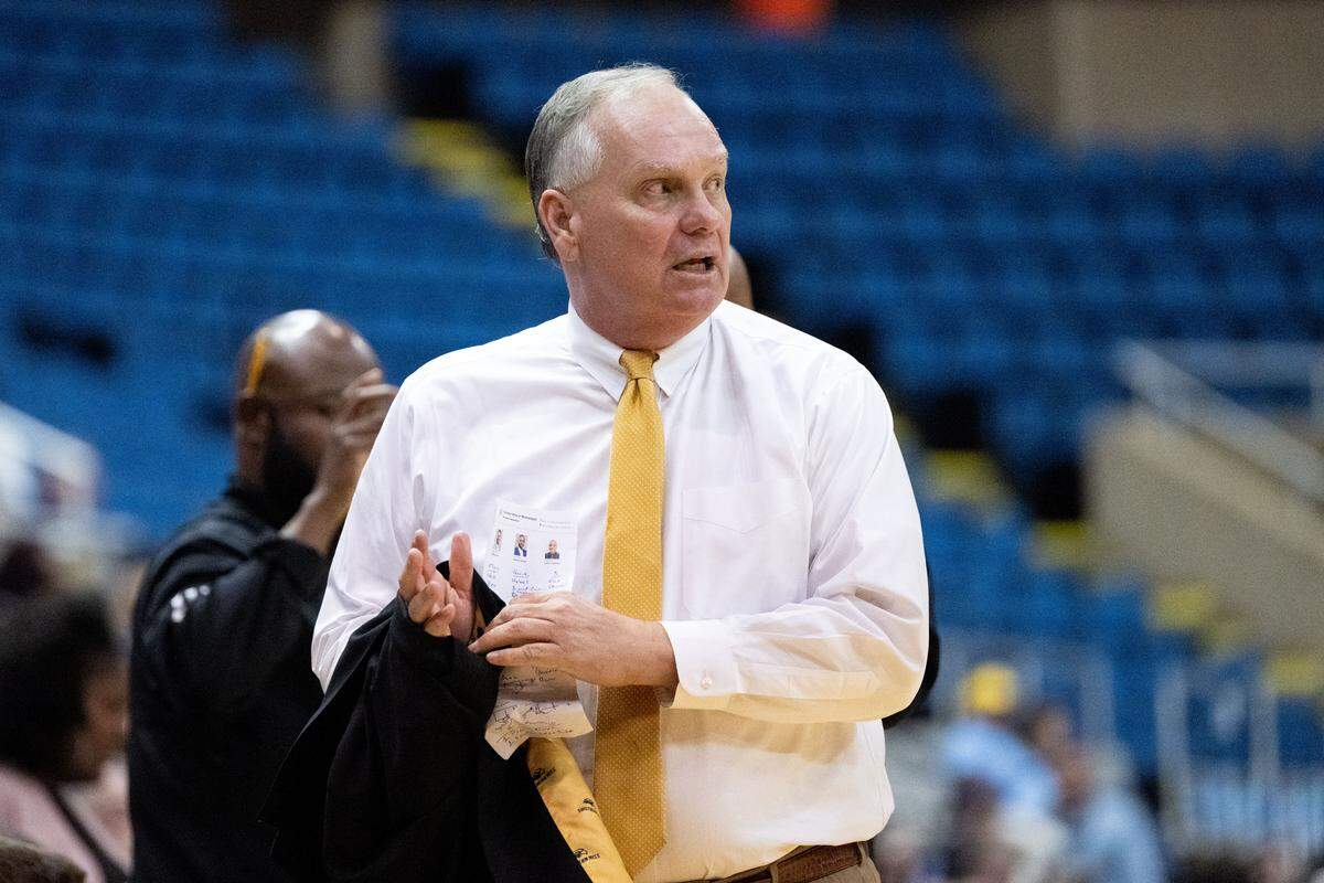Southern Mississippi head coach Jay Ladner takes off his suit jacket as his team falls behind.