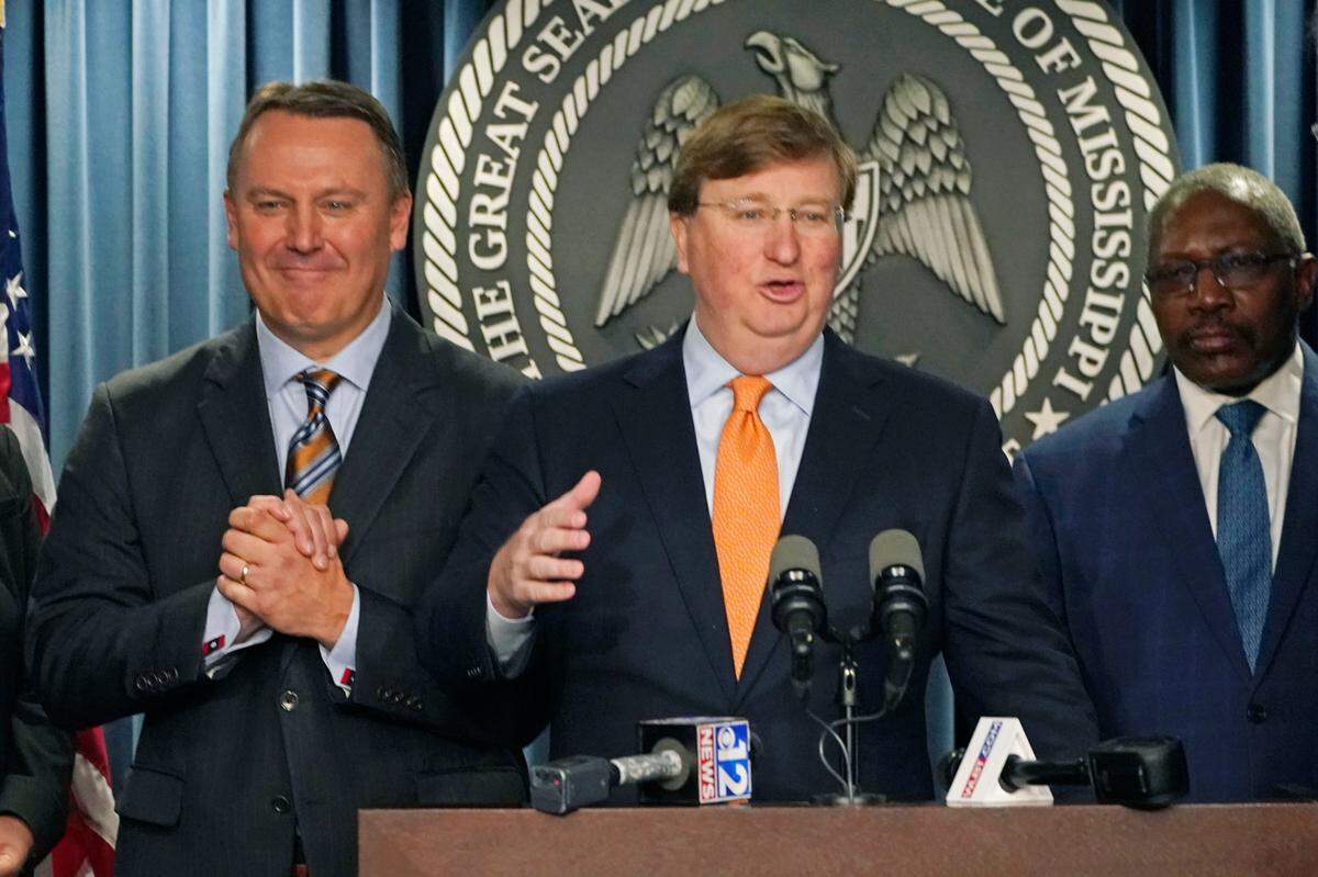 Mississippi Gov. Tate Reeves, center, announces a tech company will invest $10 billion to build two data processing centers that will create 1,000 jobs in central Mississippi, during a Wednesday news conference in Jackson.