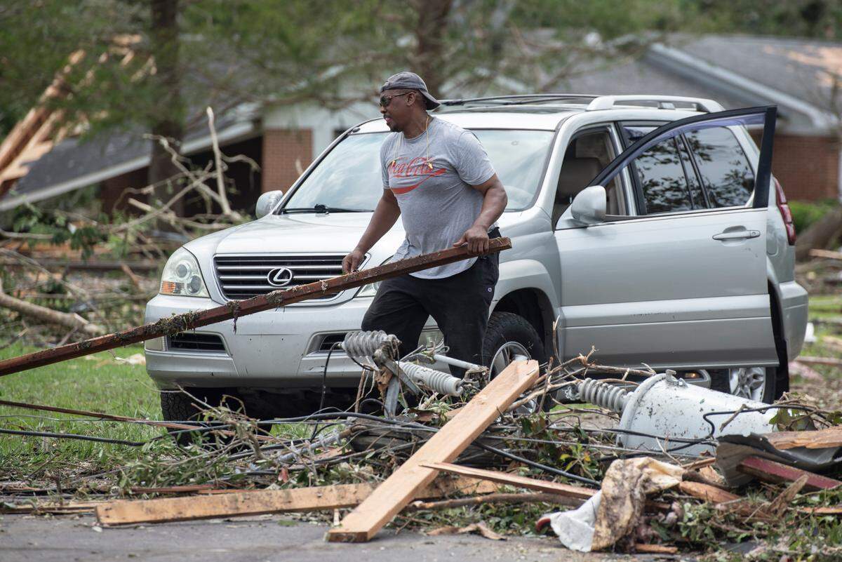 A resident clears the way for his car in Moss Point on Tuesday, June 20, 2023, after a tornado tore through the town on Monday.