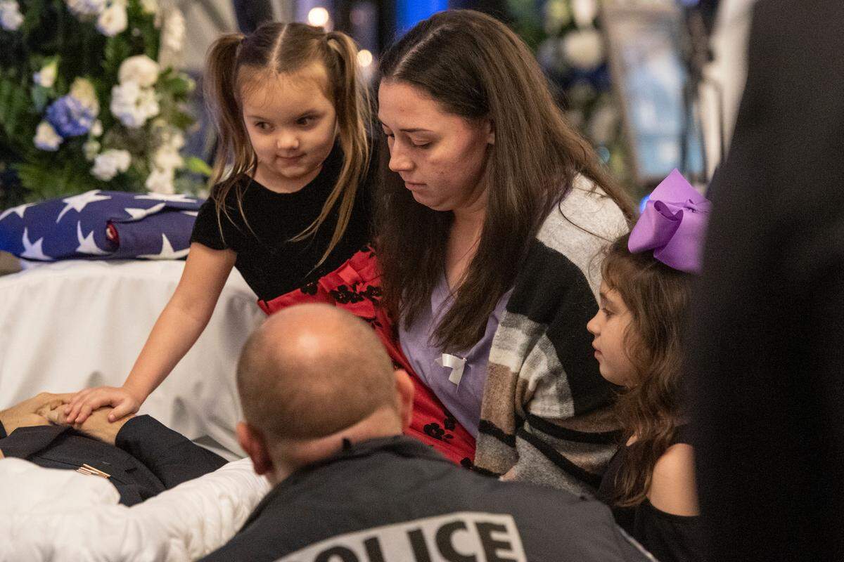 Family members of Steven Robin say their goodbyes to him during the funeral of Bay St. Louis police officers Sgt. Steven Robin and Branden Estorffe at the Bay St. Louis Community Center in Bay St. Louis on Wednesday, Dec. 21, 2022. Robin and Estorffe were killed responding to a call at a Motel 6 on Dec. 14.