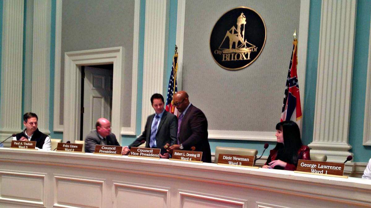 MARY PEREZ/SUN HERALD 
 Robert Deming III, standing left, voted the new Biloxi council president Tuesday, trades seats with outgoing president Felix Gines, standing right. Dixie Newman, seated to their right, was voted vice president.