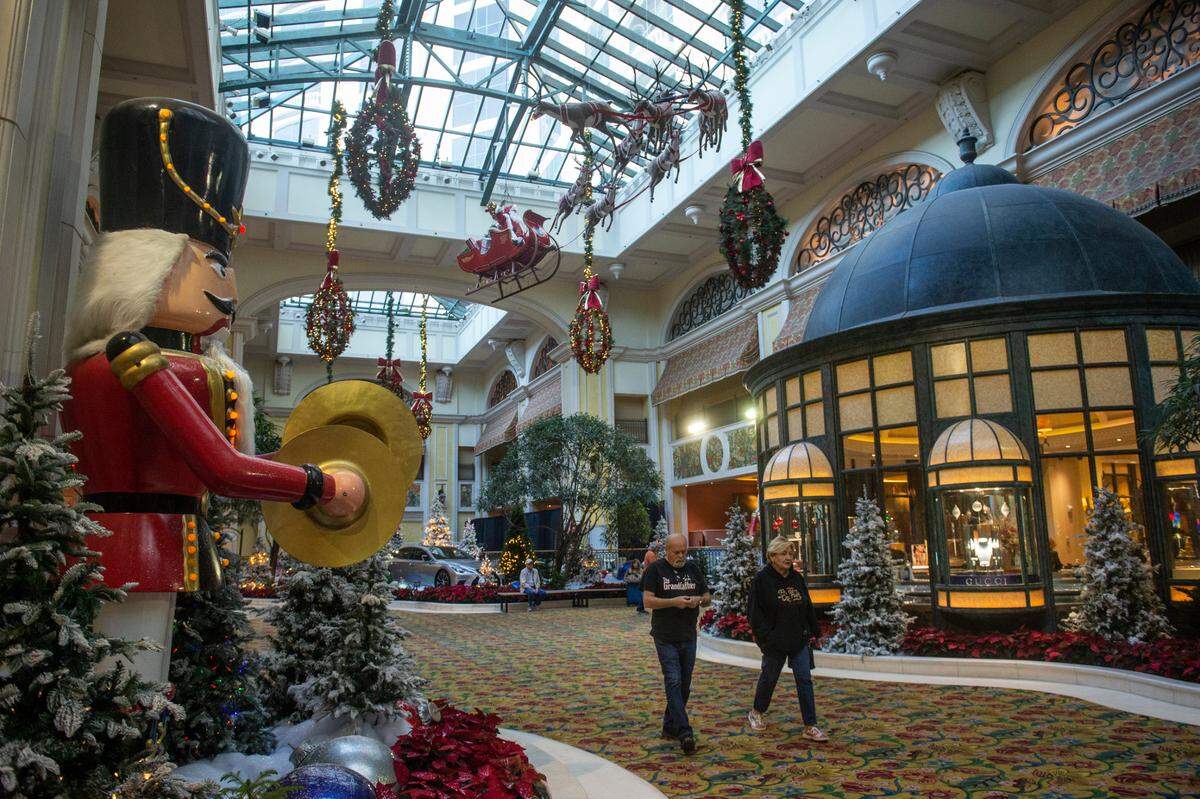 Guests walk through the at the Beau Rivage Casino in Biloxi on Thursday, Dec. 1, 2022 as Christmas decoration hang overhead.