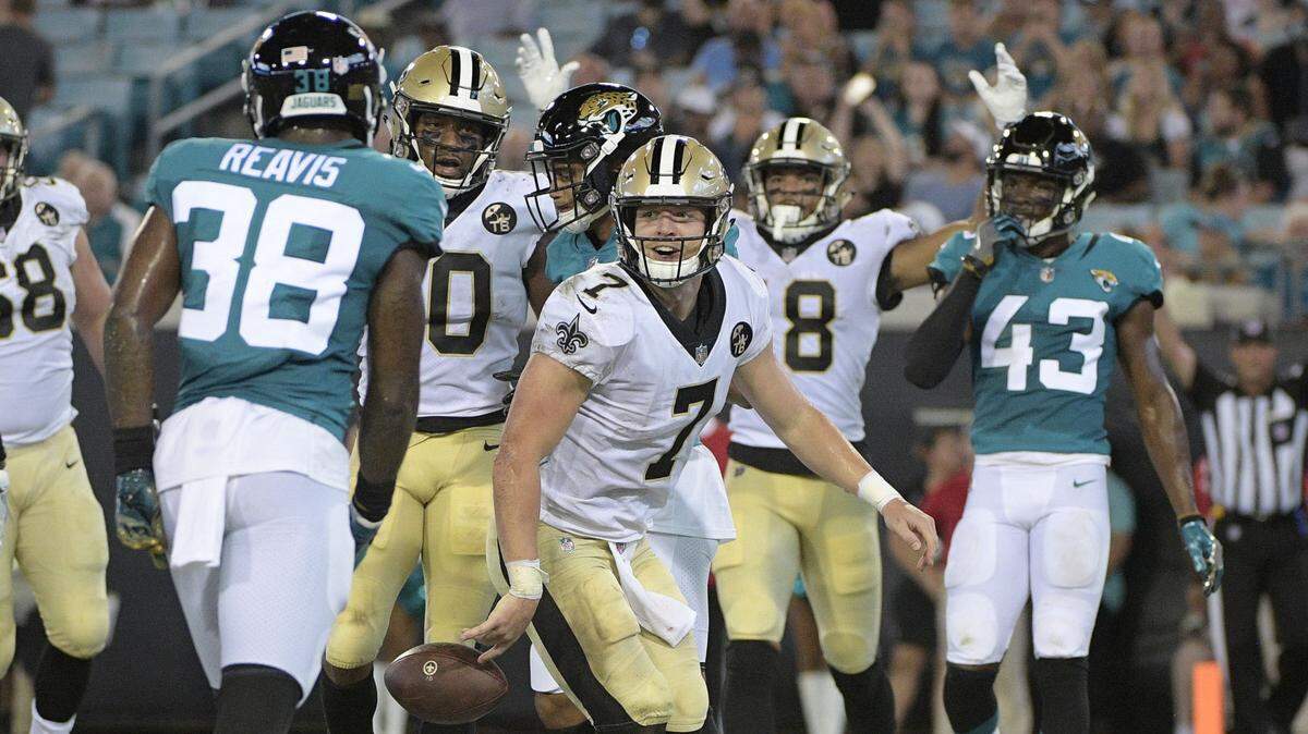 New Orleans Saints quarterback Taysom Hill celebrates his 3-yard touchdown run as the Jacksonville Jaguars’ C.J. Reavis (38) looks on during the second half of Thursday’s preseason game in Jacksonville, Fla.