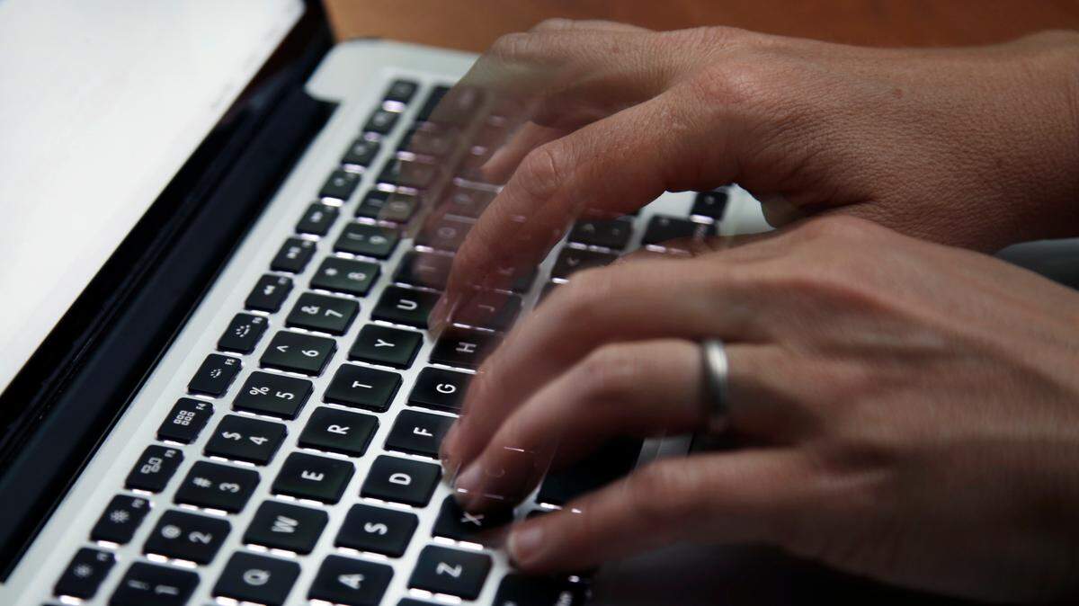 This June 19, 2017 file photo shows a person working on a laptop in North Andover, Mass. Many now are working and studying from home to limit the spread of the new coronavirus, one that’s testing how productive people can be in a pandemic. It’s also challenging the capacity of the internet, home Wi-Fi systems and video-chat services amid unprecedented demand.