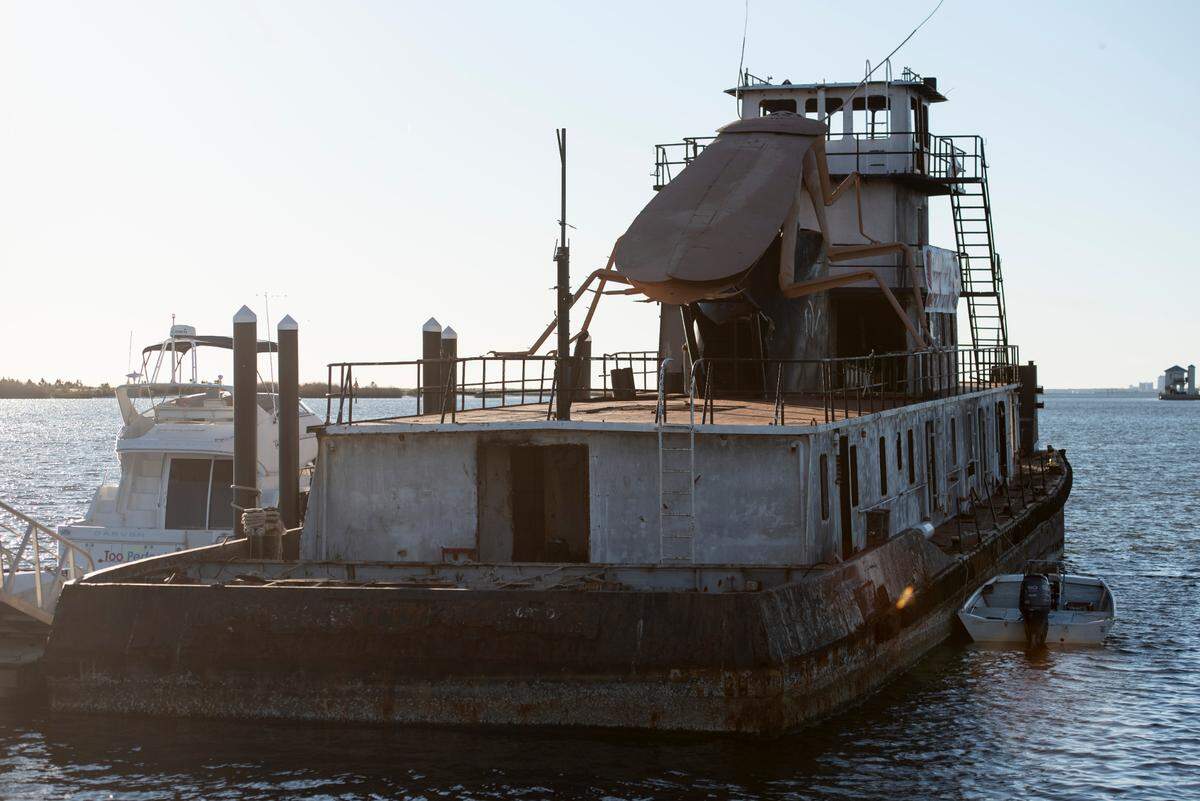 A giant steel cockroach sculpture is affixed to an old tugboat docked in Biloxi on Thursday, Nov. 21, 2024. The boat is being sunk as an artificial reef in the Gulf of Mexico off the Mississippi Coast, where it is expected to attract fish, fishermen and divers.