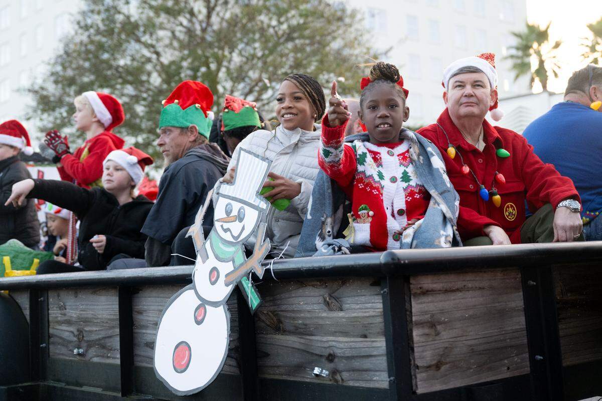 Children pass out candy from parade floats during the Champions Christmas Parade in Gulfport on Monday, Dec. 8, 2025.