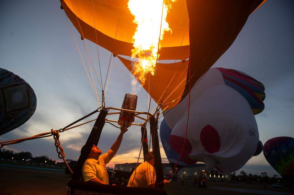 A hot air balloon pilot fires the burners inside his balloon during the Gulf Coast Hot Air Balloon Festival at OWA in Foley, Alabama on Thursday, May 4, 2023.