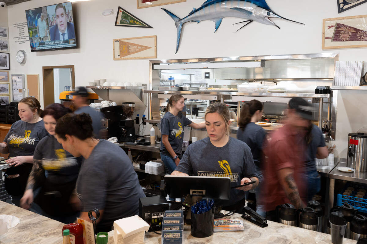 Servers bring food walk through the breakfast bar area as they pick up dishes to serve their customers during the opening day of The Downtowner in Gulfport on Tuesday, June 9, 2026.