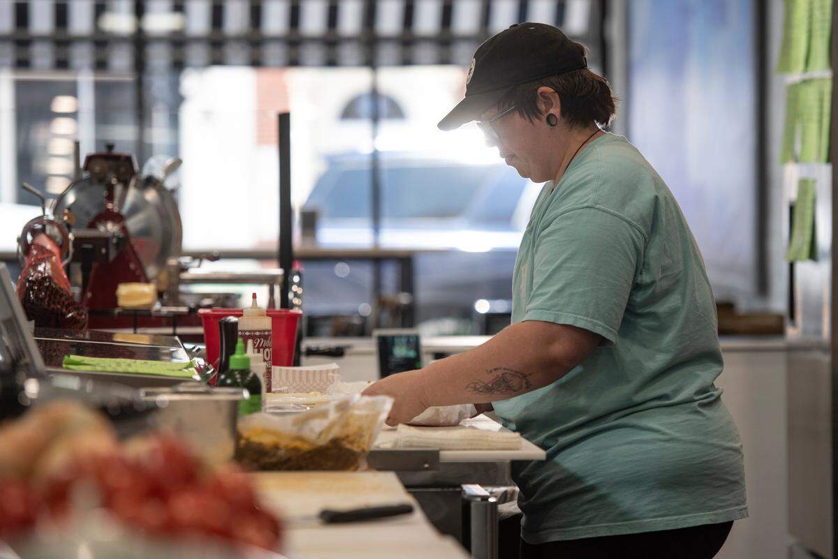 An employee prepares a sandwich at Tavi’s Salumeria in Gulfport.
