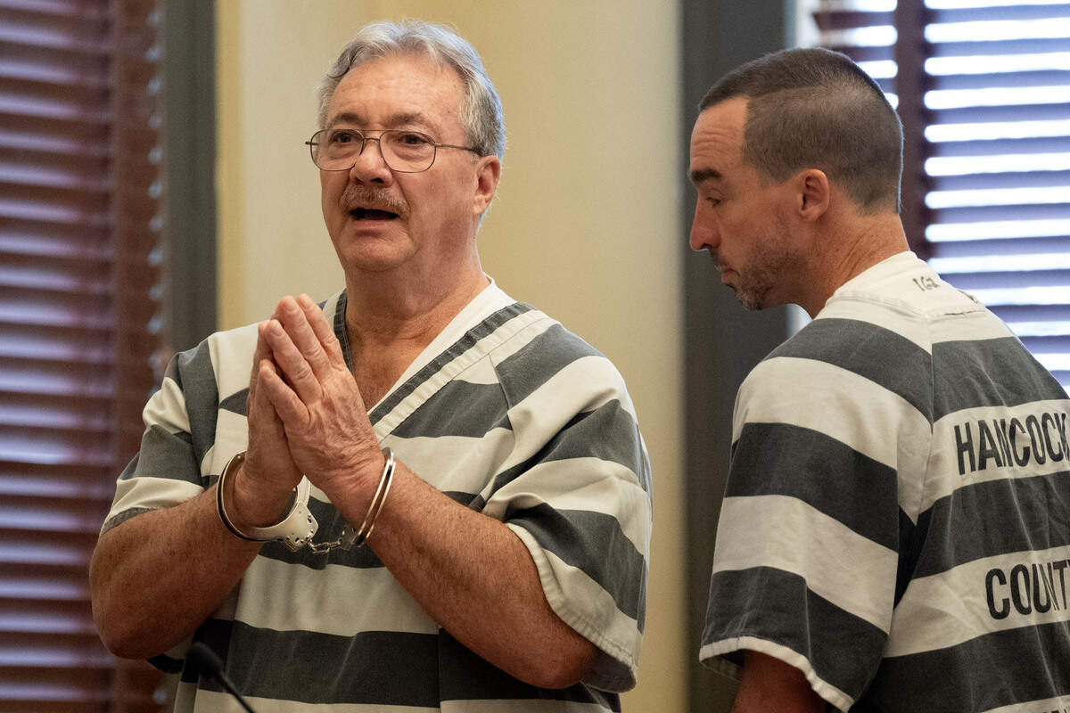 Philip Moran, left, gestures to the gallery as he exits the courtroom with his son Alan Moran, right, after their sentencing.