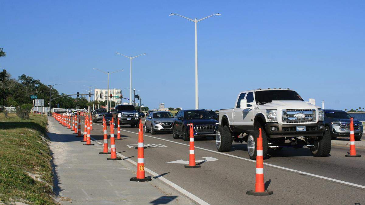 A variety of vehicles slowly parade down U.S. 90 for Scrapin’ the Coast.