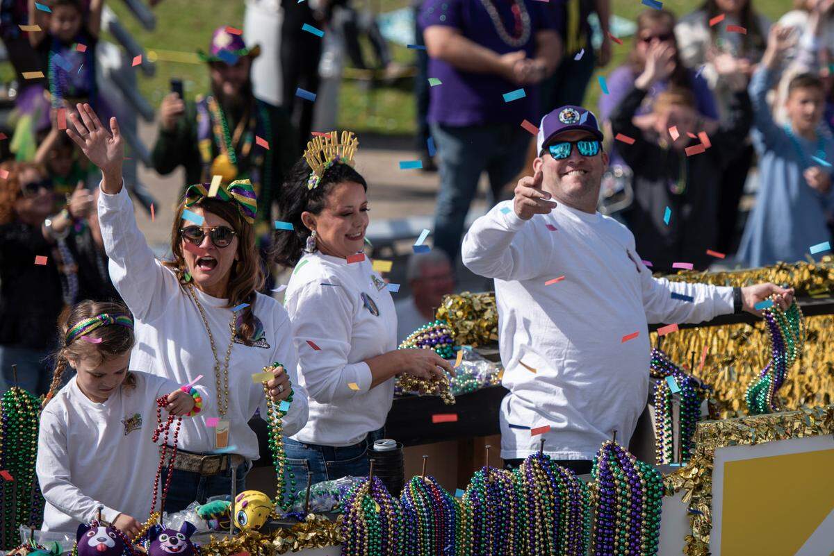 Float riders throw beads during the Gulf Coast Carnival Association’s Mardi Gras parade in Biloxi on Tuesday, Feb. 13, 2024.