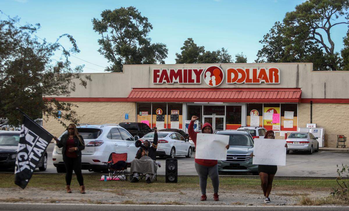 Marquell Bridges, center, chants “Hands up, Don’t Shoot” outside of Family Dollar on Pass Road in Gulfport, where he and others have been protesting for justice in the police killing of 15-year-old Jaheim McMillan.