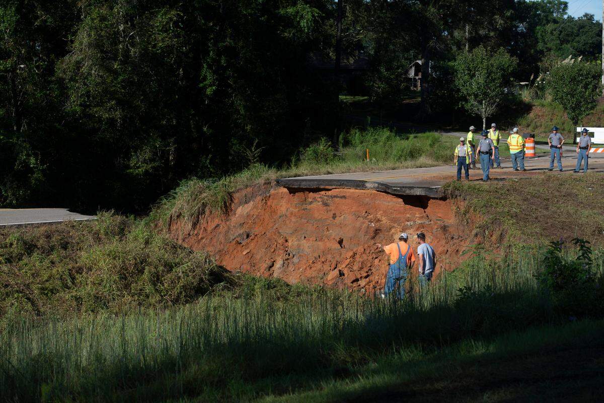 Crews work to survey damage after a portion of Mississippi Highway 26 in George County collapsed late Monday night killing two people and injuring 10 others, 3 of them critically, due to heavy rains from Hurricane Ida.